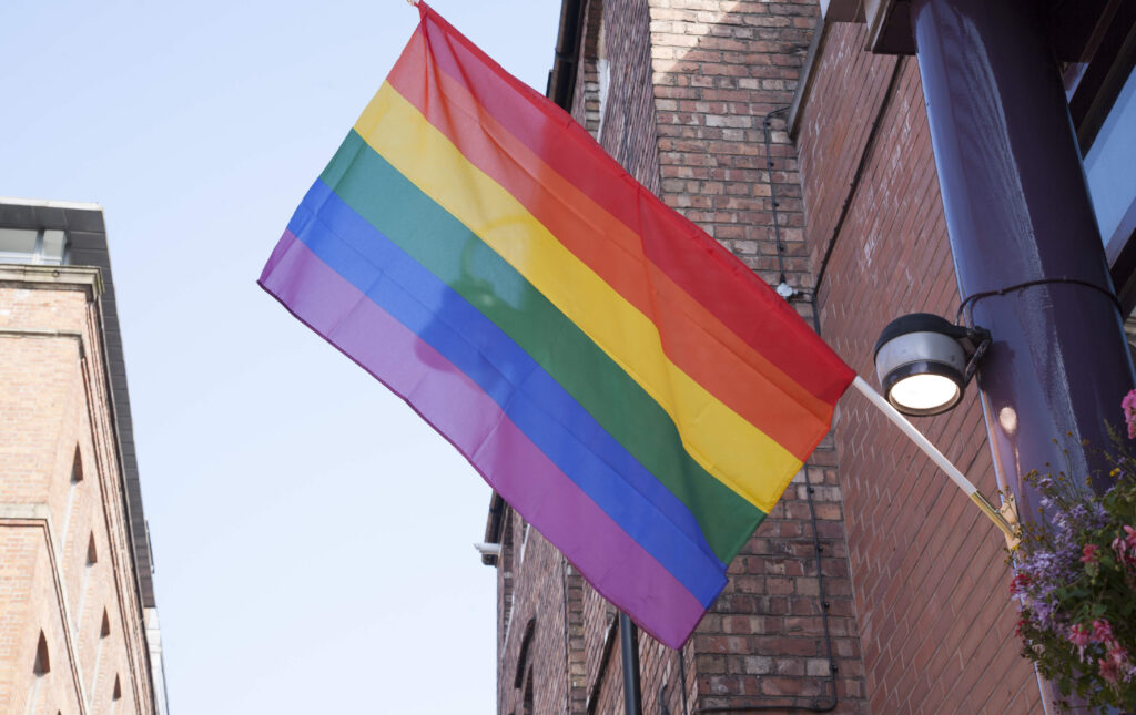 een regenboogvlag hangt in canal street, manchester